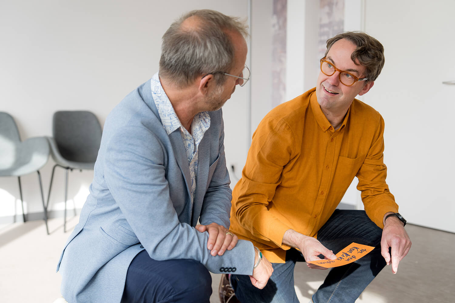 Gruppe im Seminarraum steht um farbiges Persönlichkeitsrad; Trainer erklärt die Übung