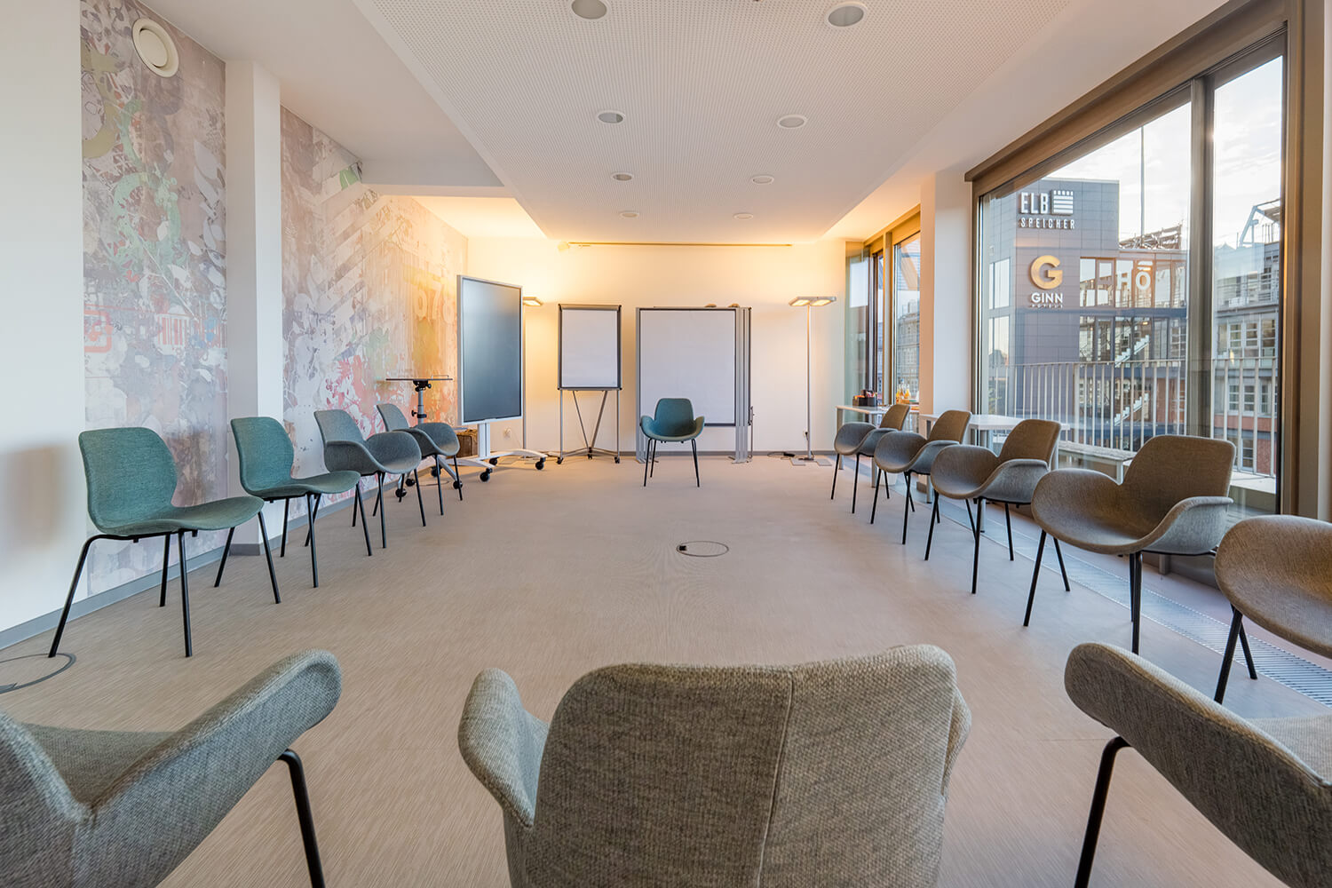 Seminarraum Hamburg – heller Stuhlkreis mit Flipcharts und Glasfront