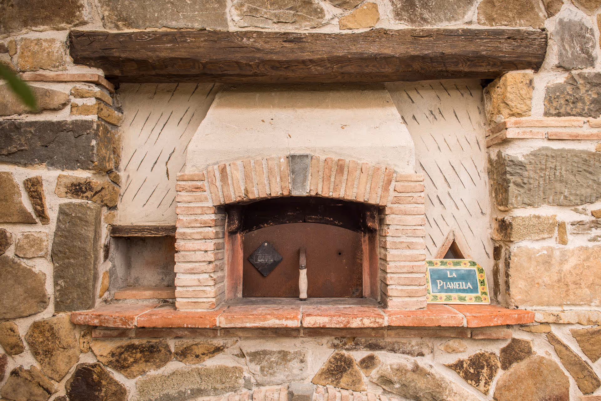 Traditional wood-fired pizza oven built into a stone wall