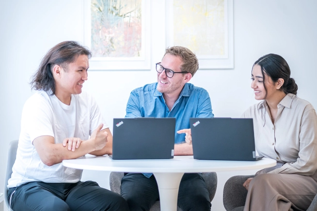 Ein diverses Team von Fachexperten arbeitet konzentriert an Computern in einem modernen Büroumfeld.