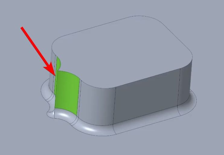 3D CAD model of a rectangular object with rounded corners, showing a green highlighted vertical section and a red arrow pointing to it.