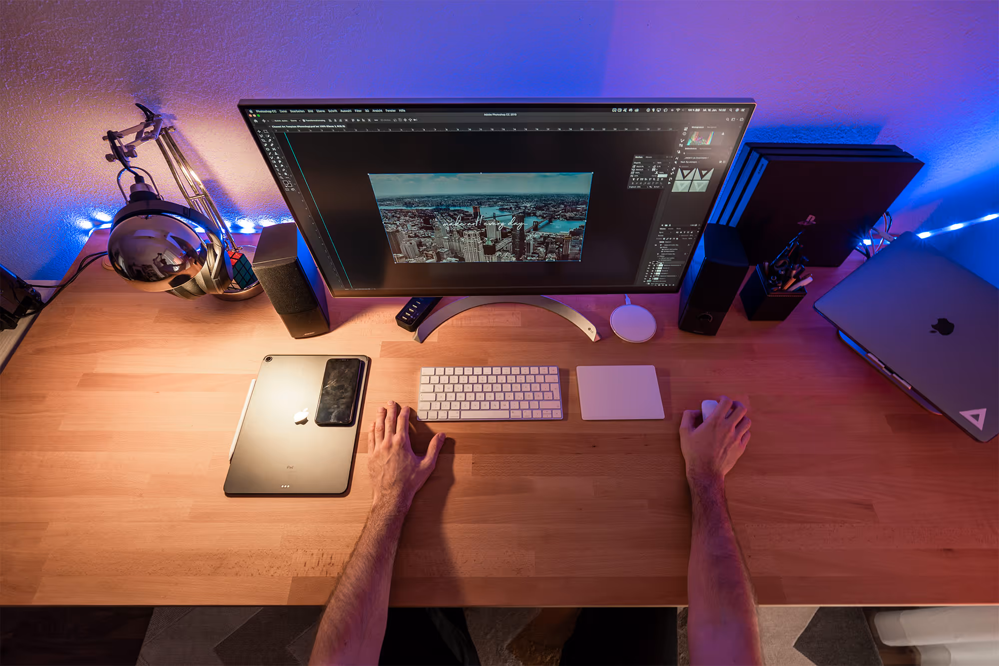 Person arbeitet an einem modernen Schreibtisch mit RGB-Beleuchtung.