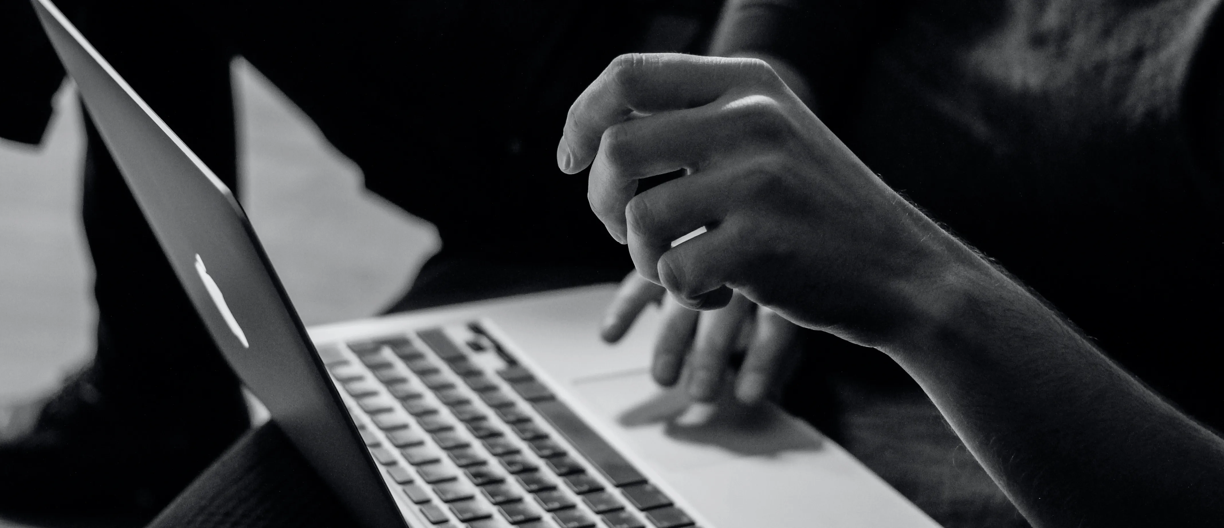 Hand auf Laptop-Tastatur, schwarz-weiß