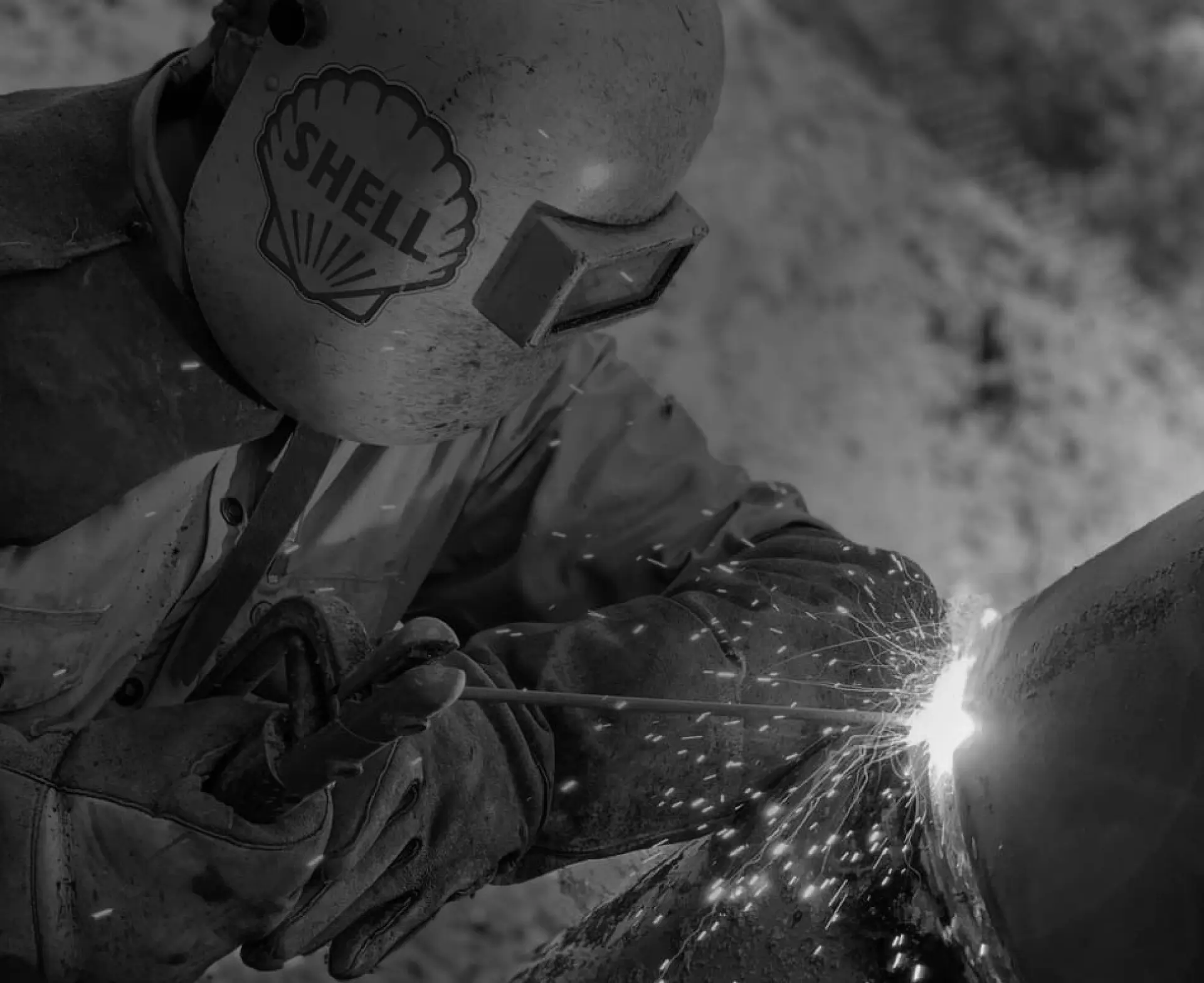 welder with mask and gloves on background overlay