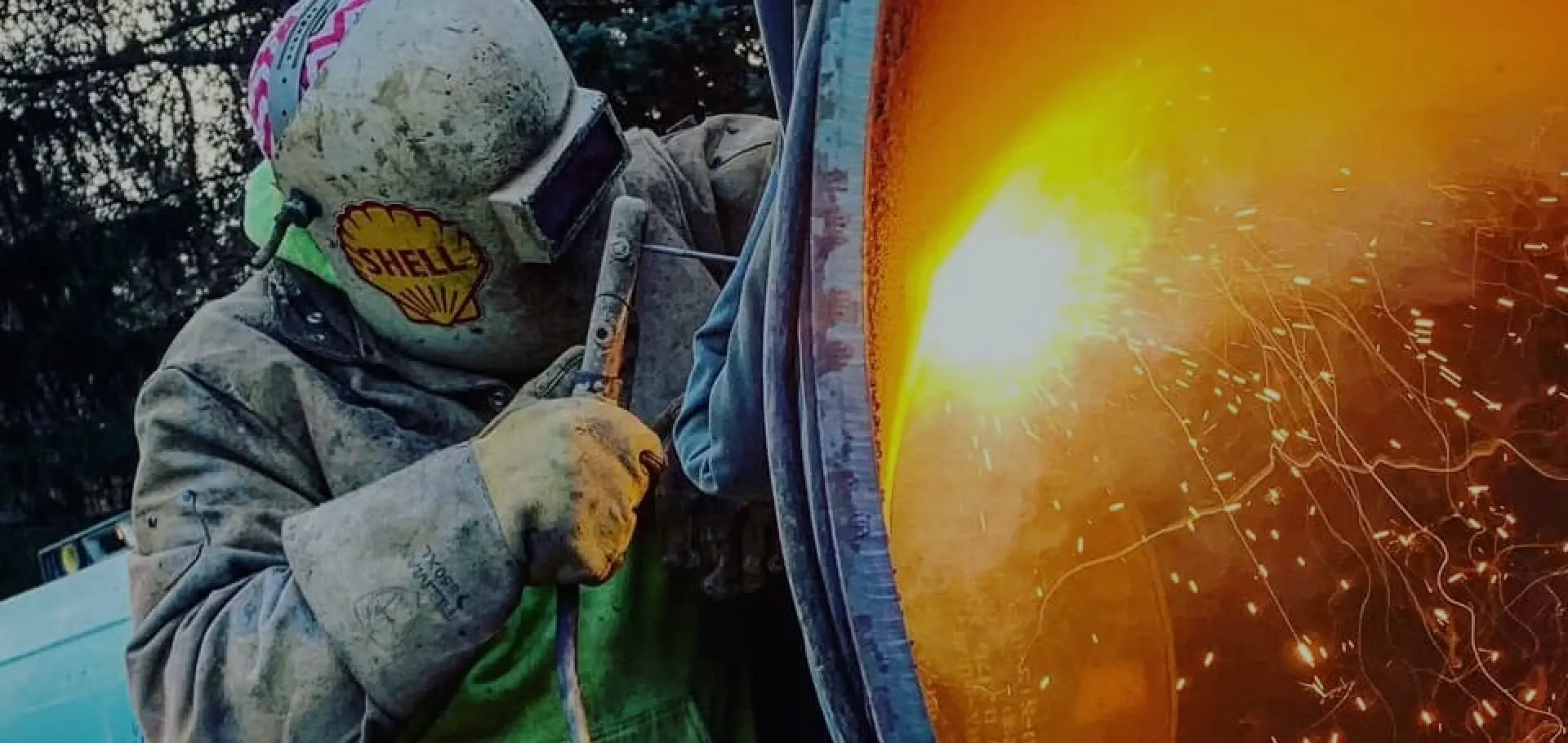 welder using tools to weld large piping