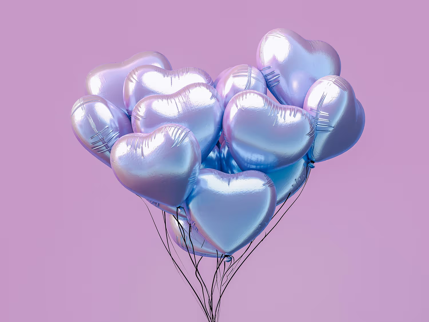 Hjärformade folierade ballonger mot som formar ett hjärta, mot en ljusrosa bakgrund.