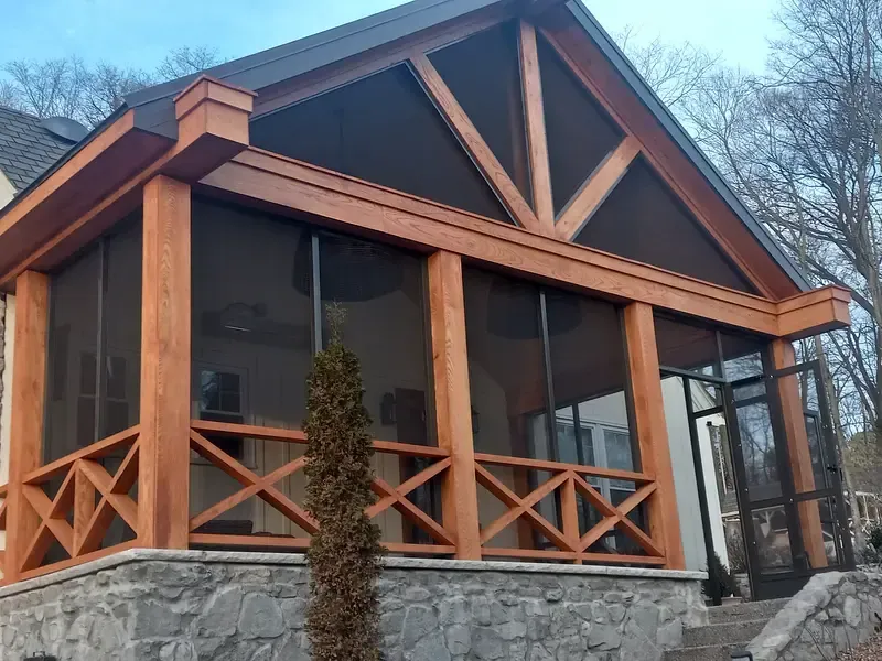 Custom screened-in porch with cedar wood framing and stone foundation built by All Weather Products in Evansville, IN.