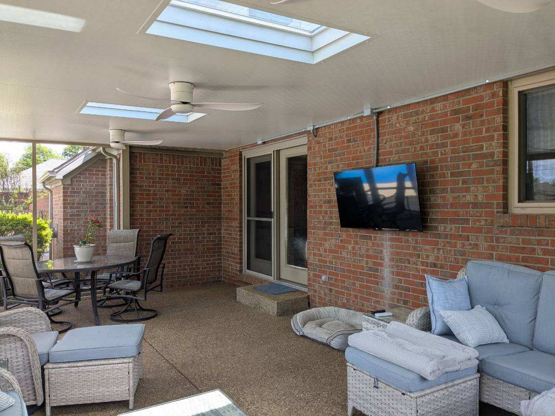 nterior view of a custom screen room built by All Weather Products in Newburgh, IN, featuring skylights, ceiling fans, and comfortable seating for year-round outdoor living.