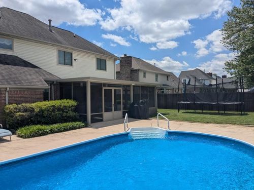 Custom screen room built by All Weather Products in Newburgh, IN, overlooking a backyard pool and patio area, designed for year-round outdoor comfort and shade.