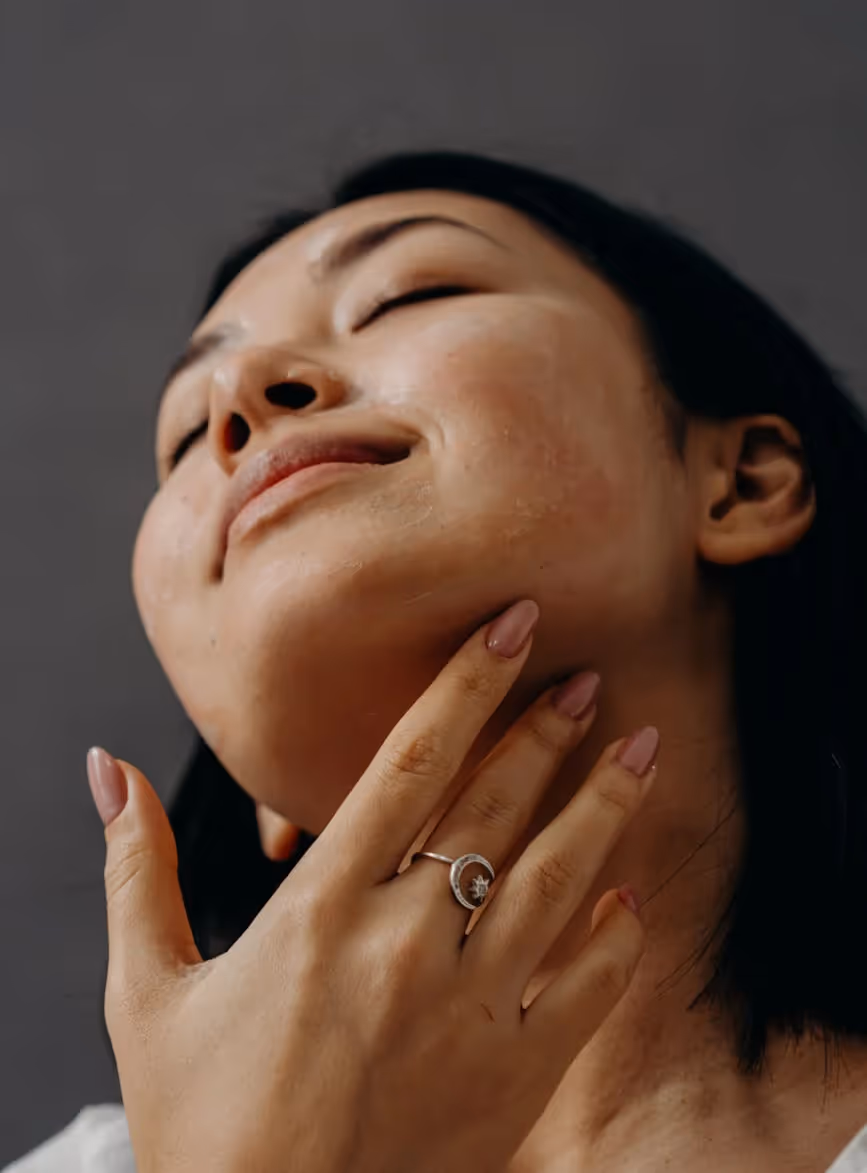 A woman holding her hand up to her face.