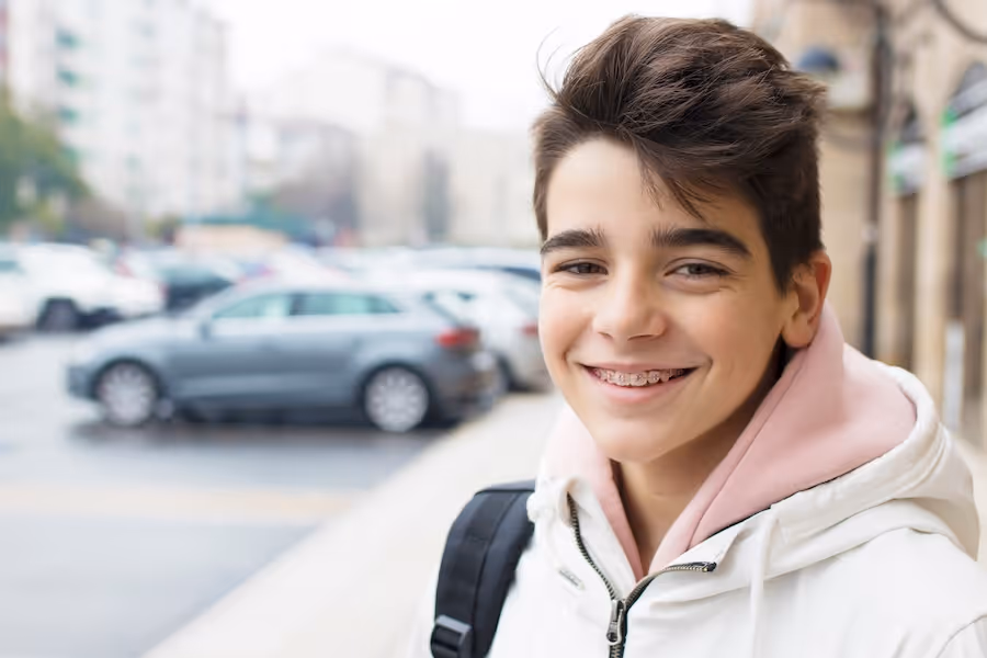 A young boy with a backpack on a city street.
