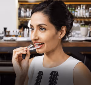 Woman wearing a white shirt holding her Invisalign