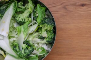 Leafy greens in a bowl on a brown table
