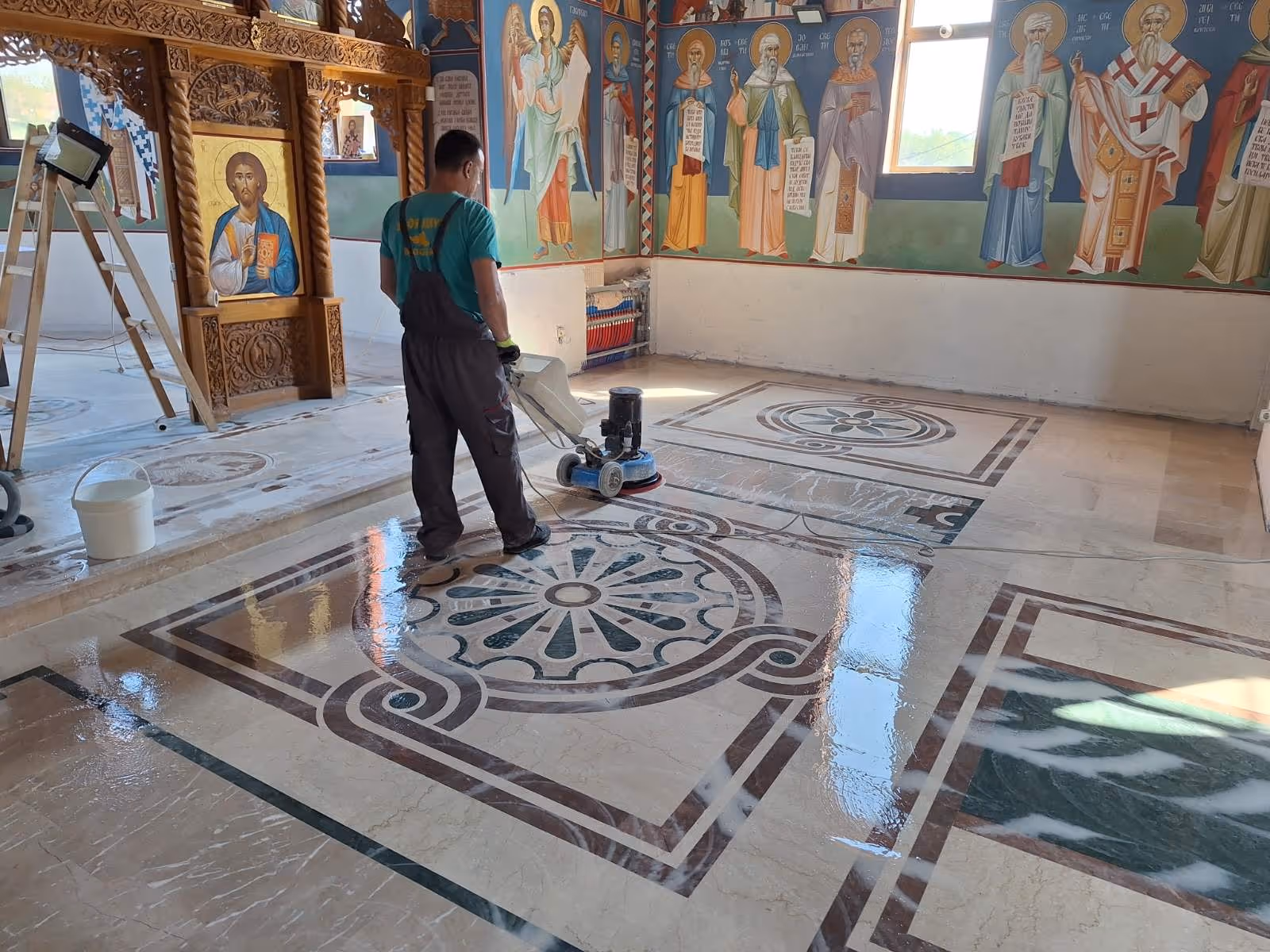 zaposleni polira mermer u crkvenim prostorijama
