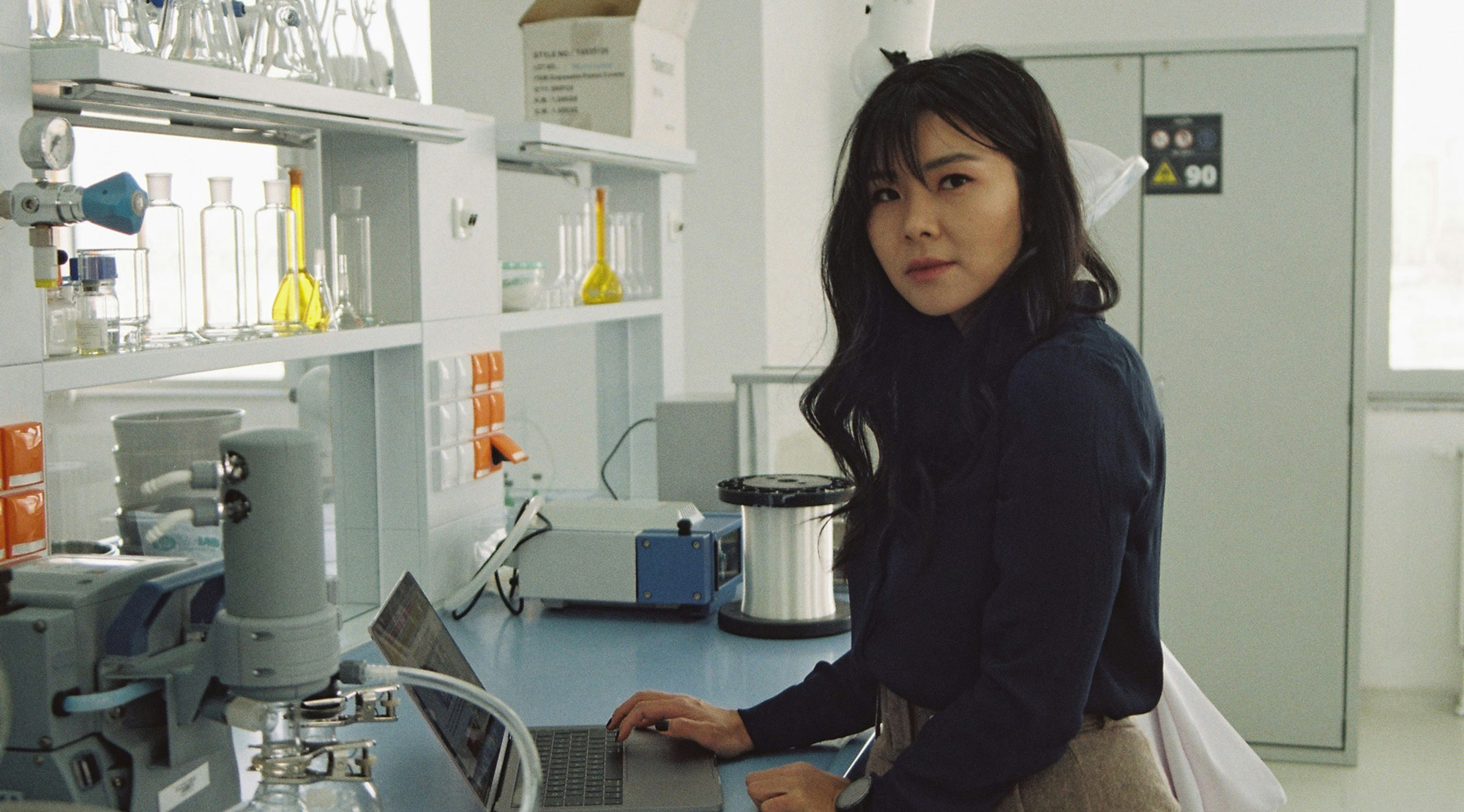 A woman using a laptop in a lab.