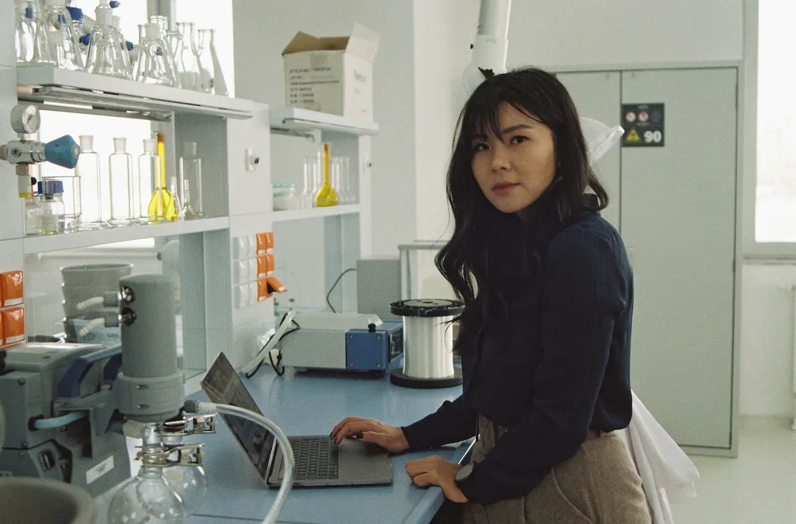 A woman using a laptop in a lab.