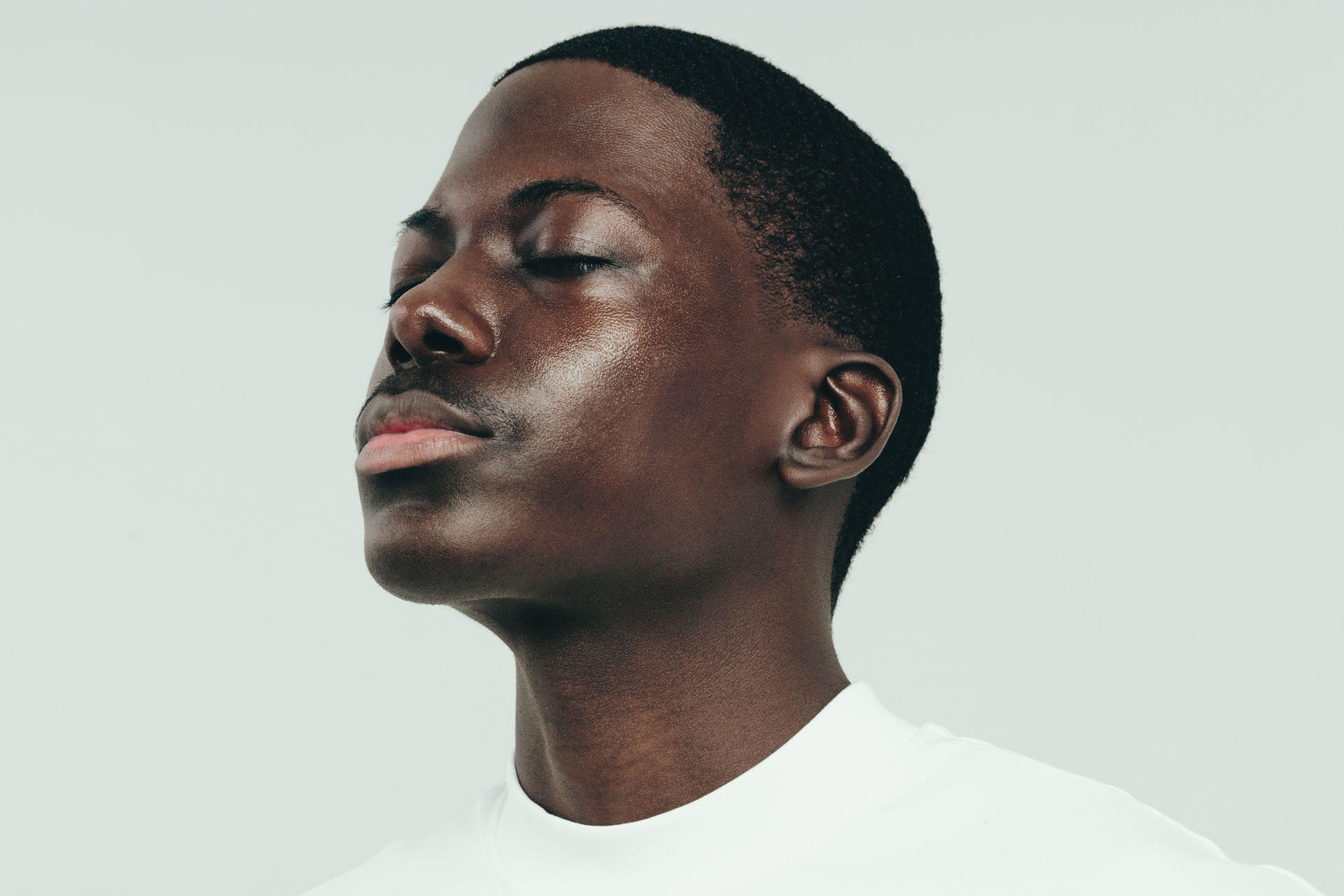 A man looking to the side with his eyes closed.