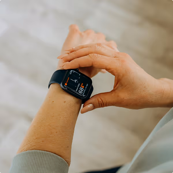 Point-of-view shot of a person checking their Kinētiq wearable health tracker for real-time energy tracking.