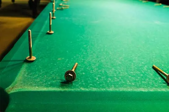 screws on a green felt pool table