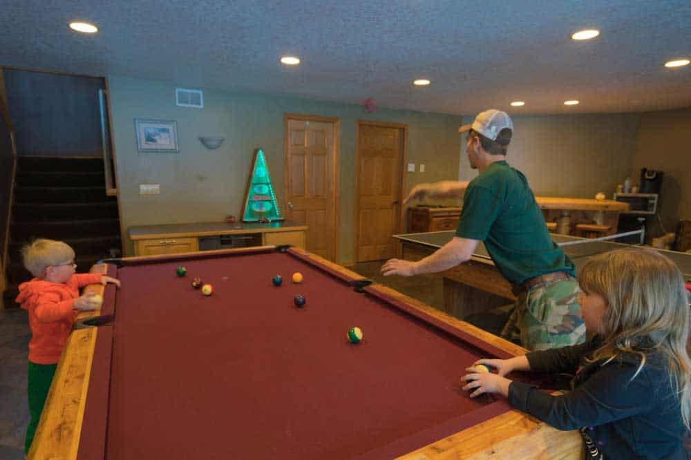 a family playing bosstoss in next to a maroon pool table