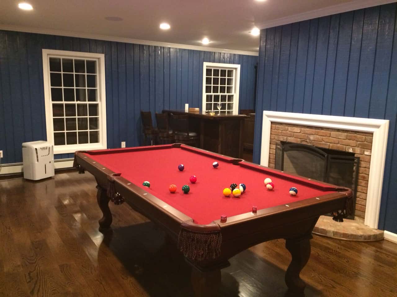 red pool table in a blue room with a fireplace