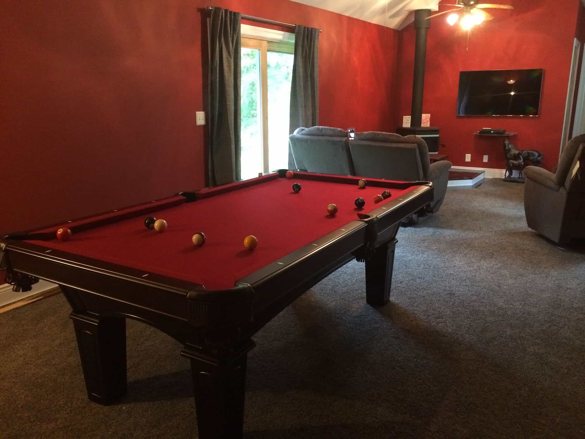 red pool table with wood stove