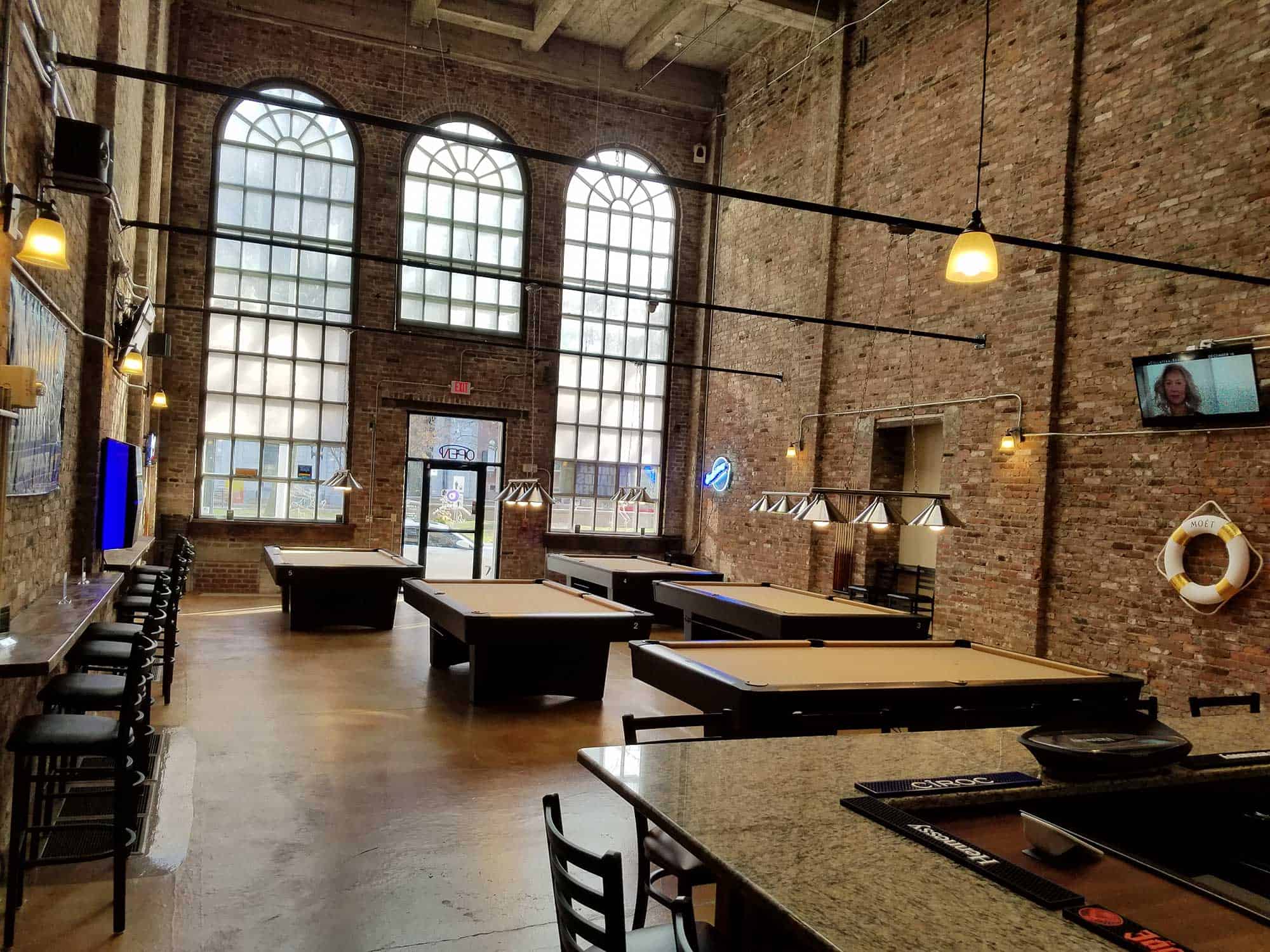 five tan pool tables at a bar