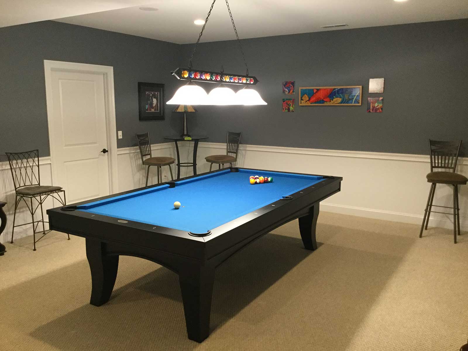 blue pool table with overhead billiard lighting