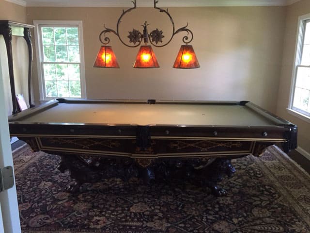 tan brown pool table with orange billiard lighting