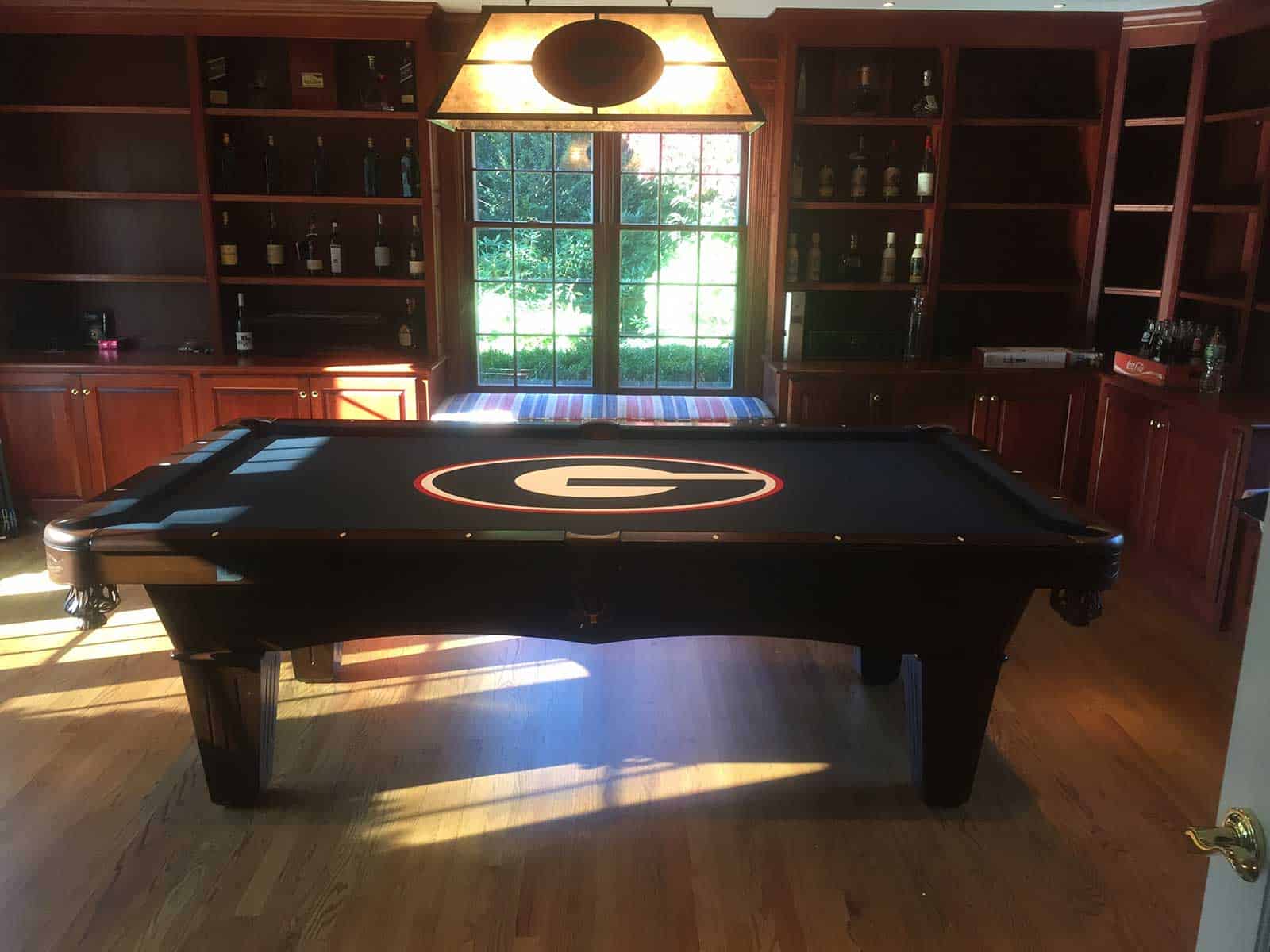 dark green pool table with georgia logo and billiard lighting