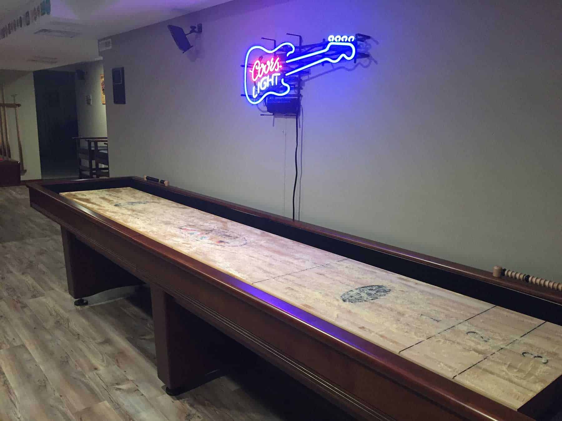 shuffleboard with coors light neon sign