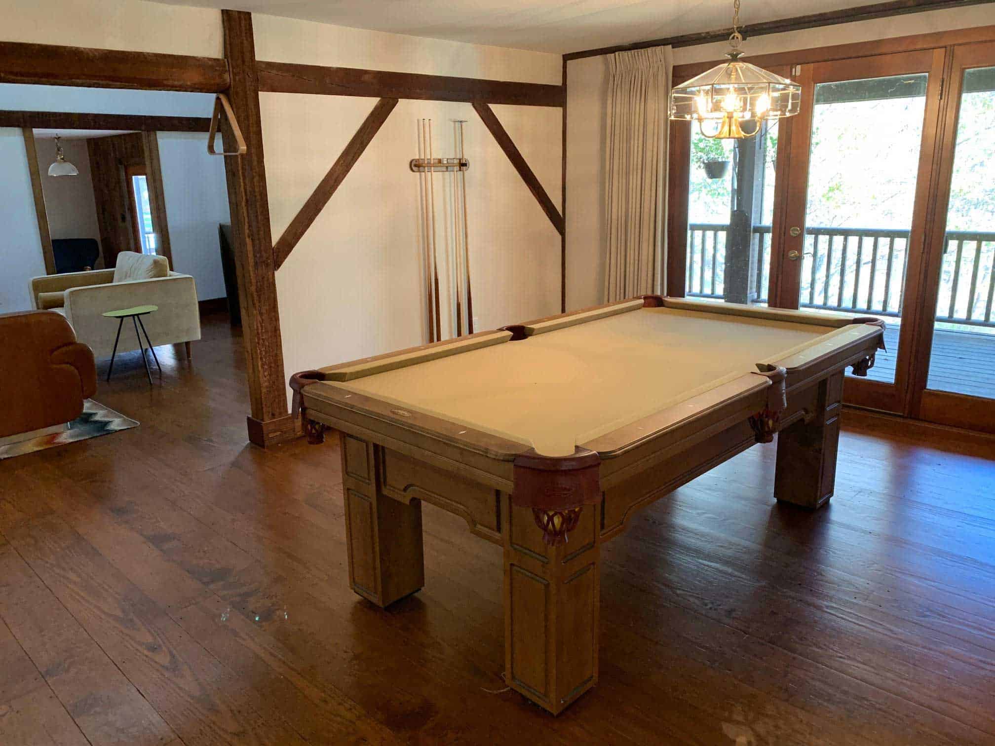 yellow tan pool table with a cue rack