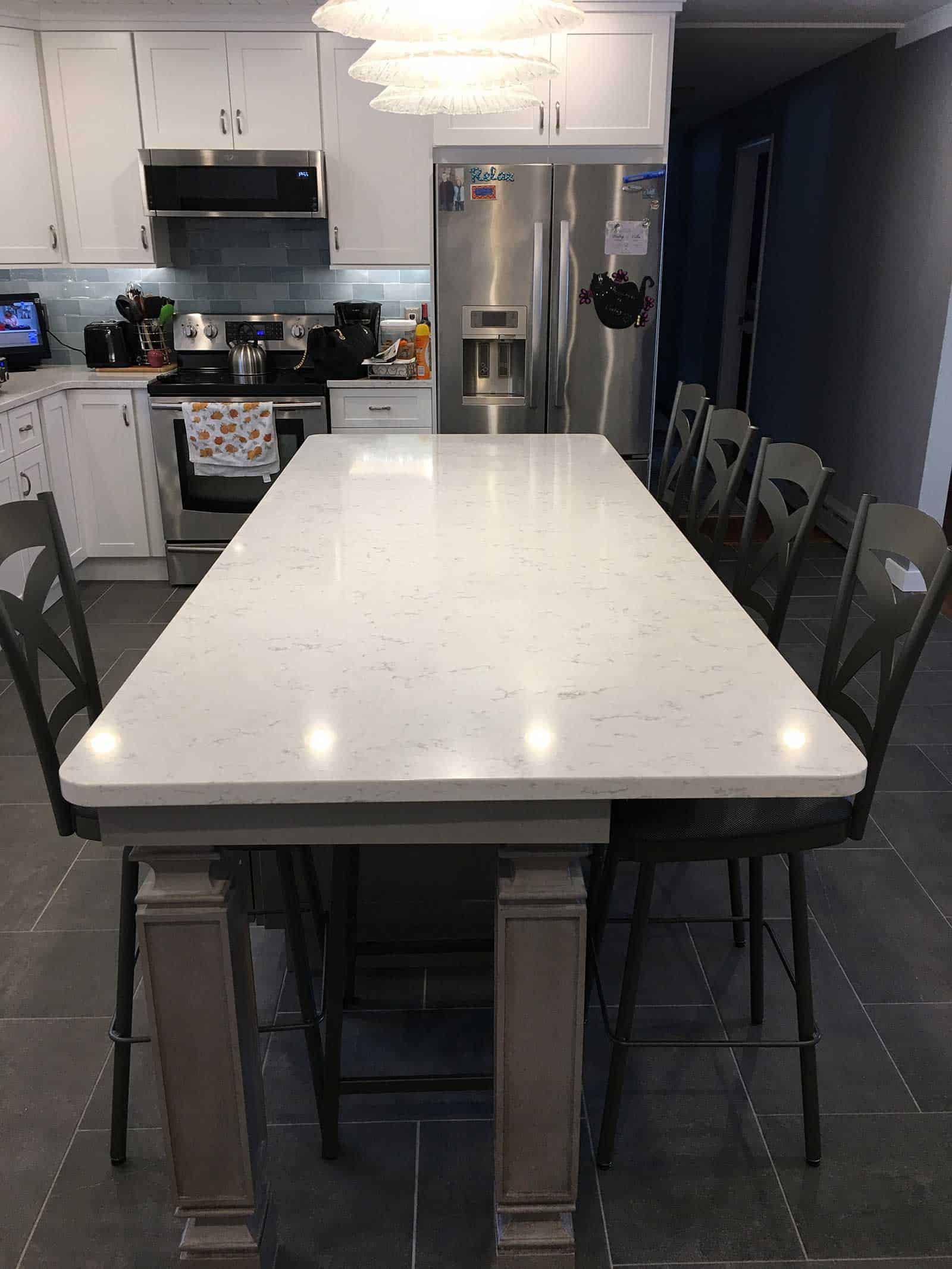 black kitchen stools at a marble island