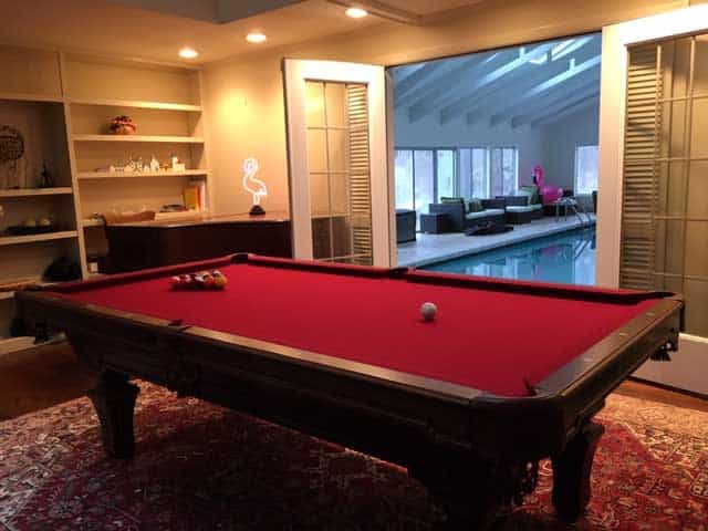 red pool table with an indoor swimming pool