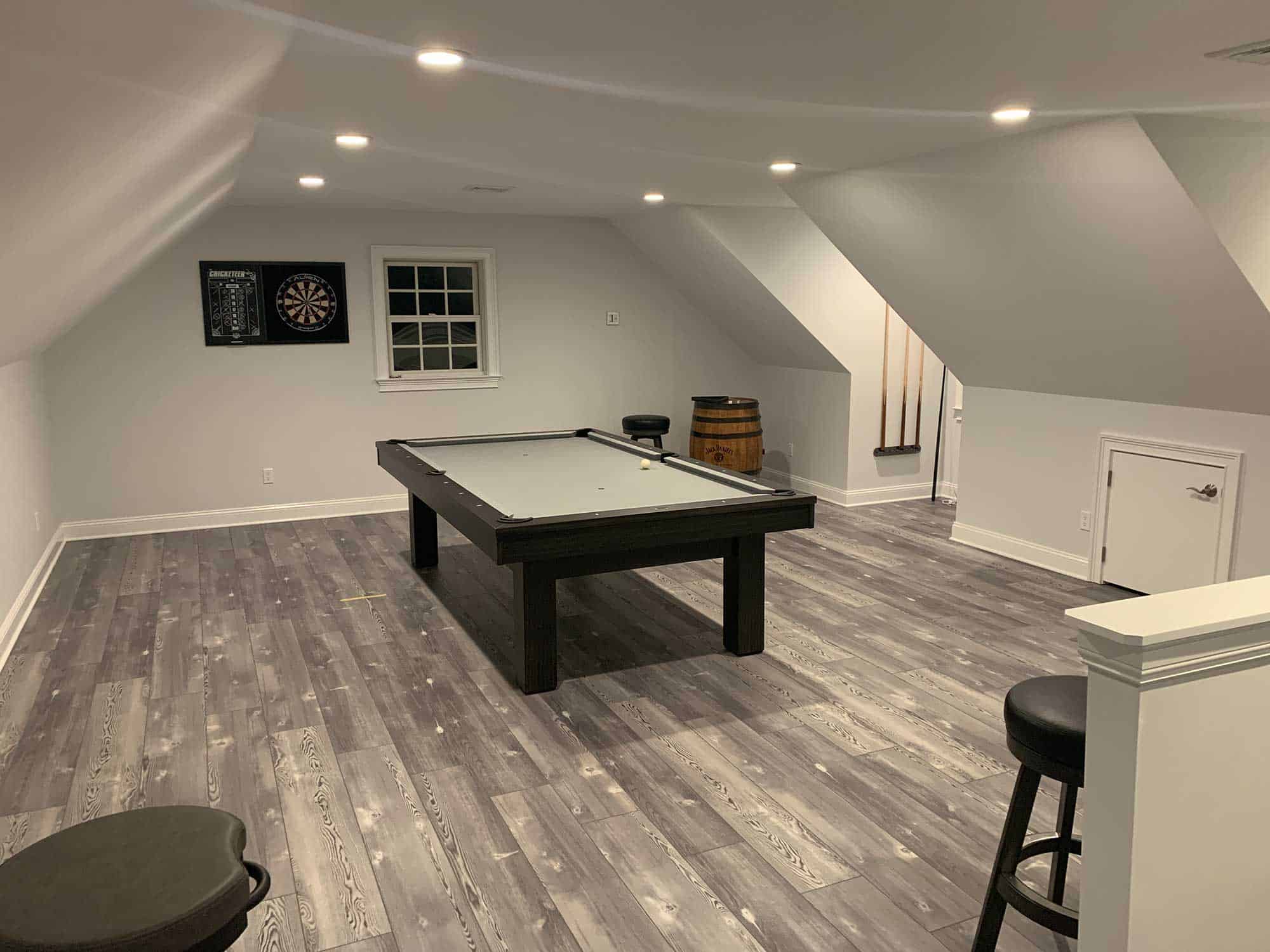 white pool table with darts and a scoreboard and bar stools