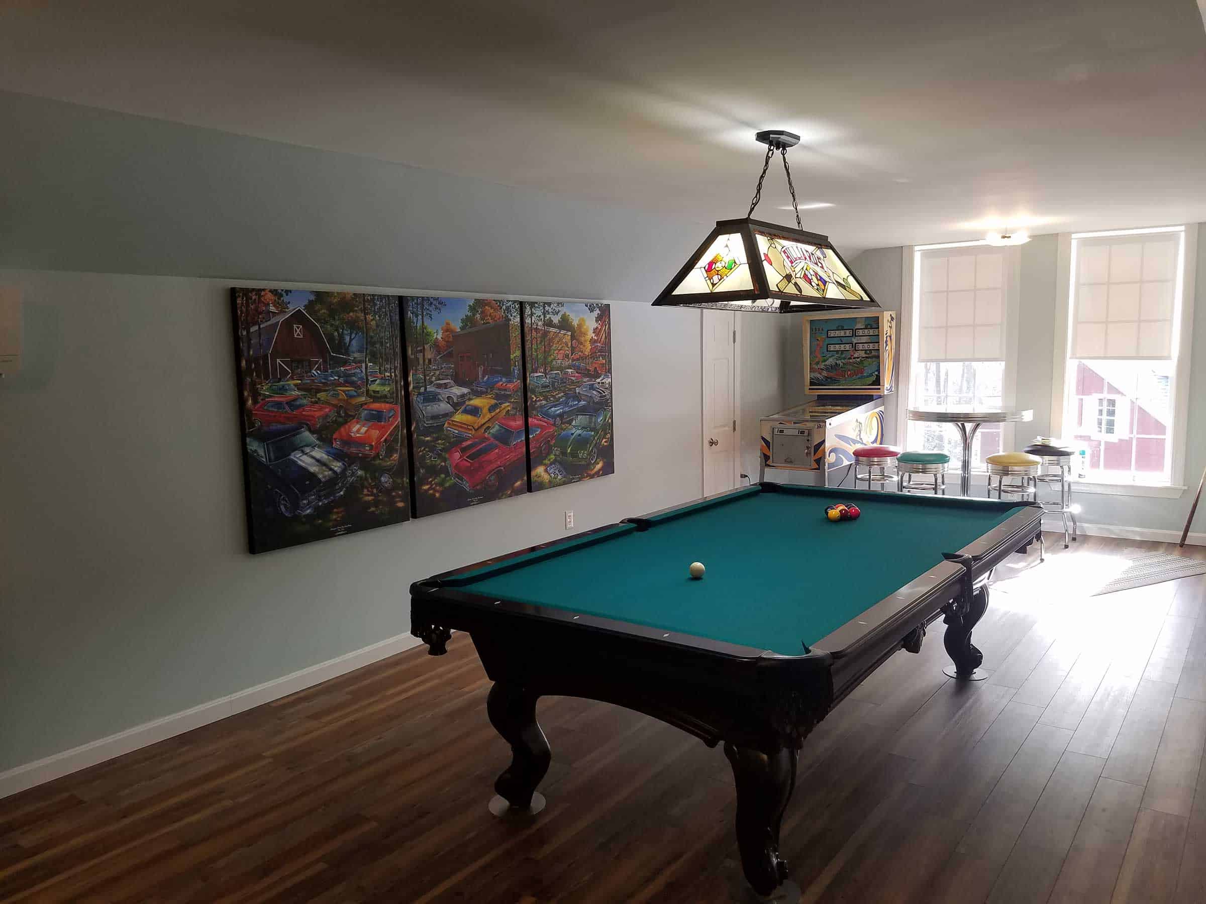 green pool table with overhead billiard lighting