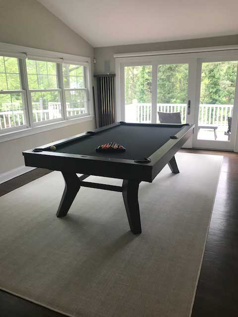 pool table on a porch with a cue rack 