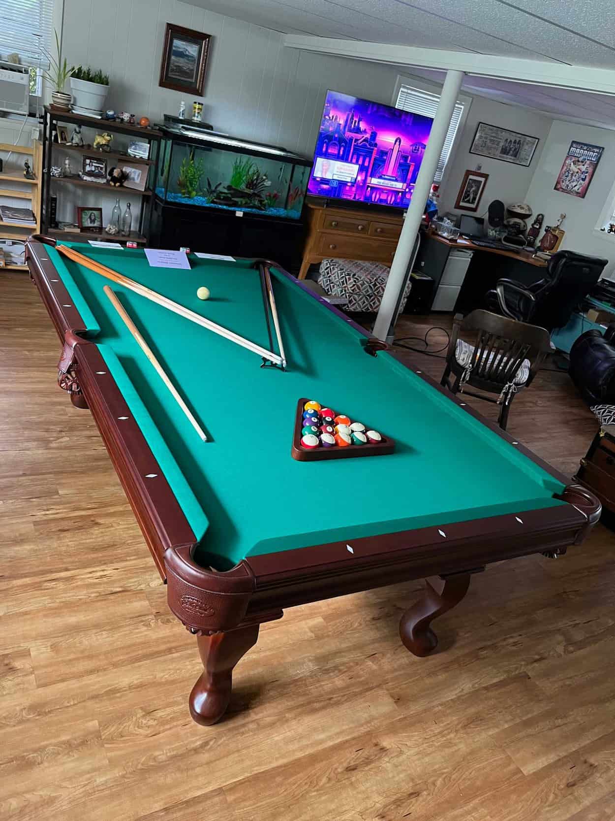 green pool table with an aquarium in the background