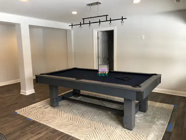 black and grey pool table with billiard lighting