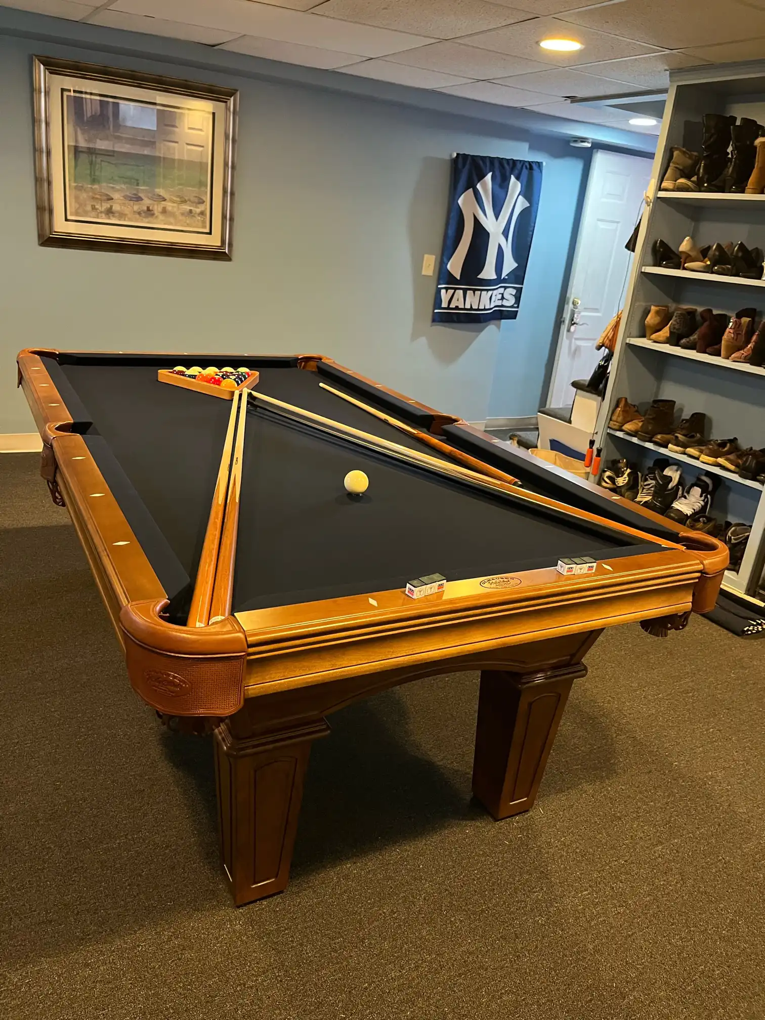Olhausen Belmont table with a Yankees poster and shoe rack in the background
