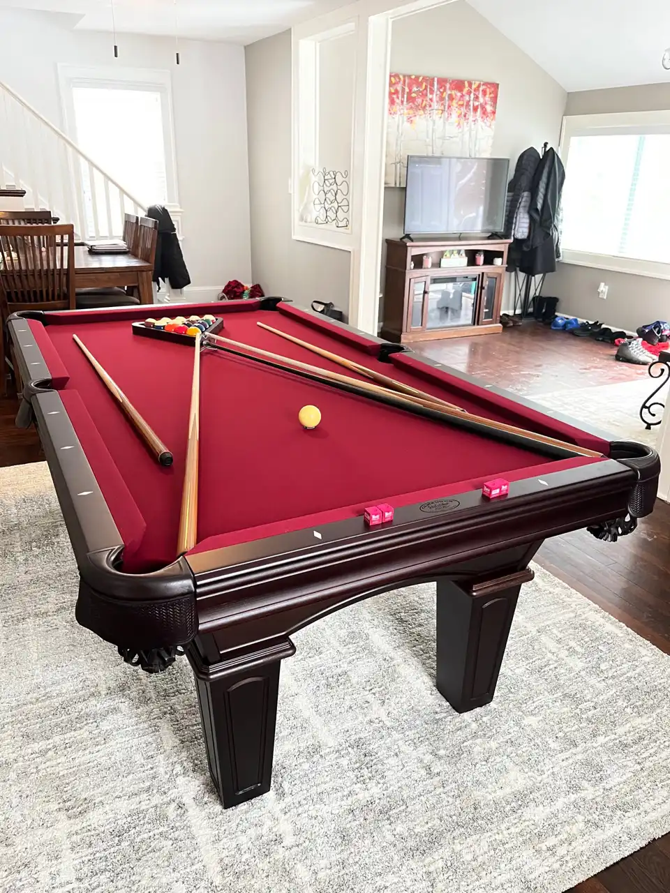 red olhuasen pool table in a white room with a grey carpet
