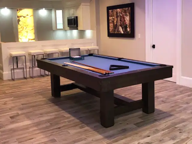 blue pool table with a white bar in the background