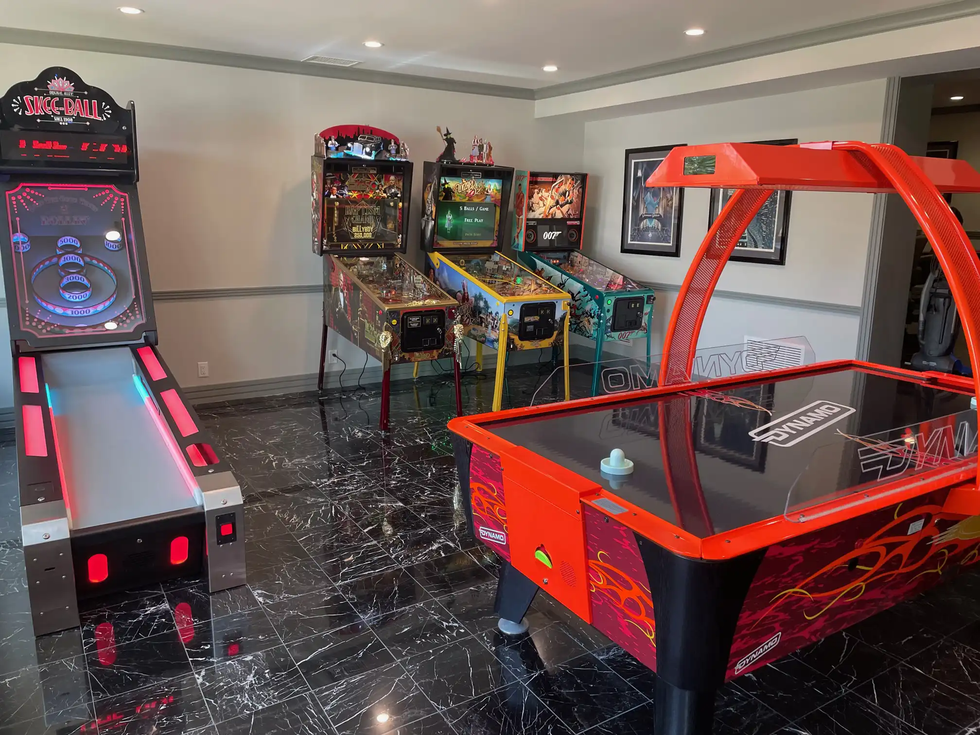 Arcade room with skee ball, air hockey, and three pinball machines
