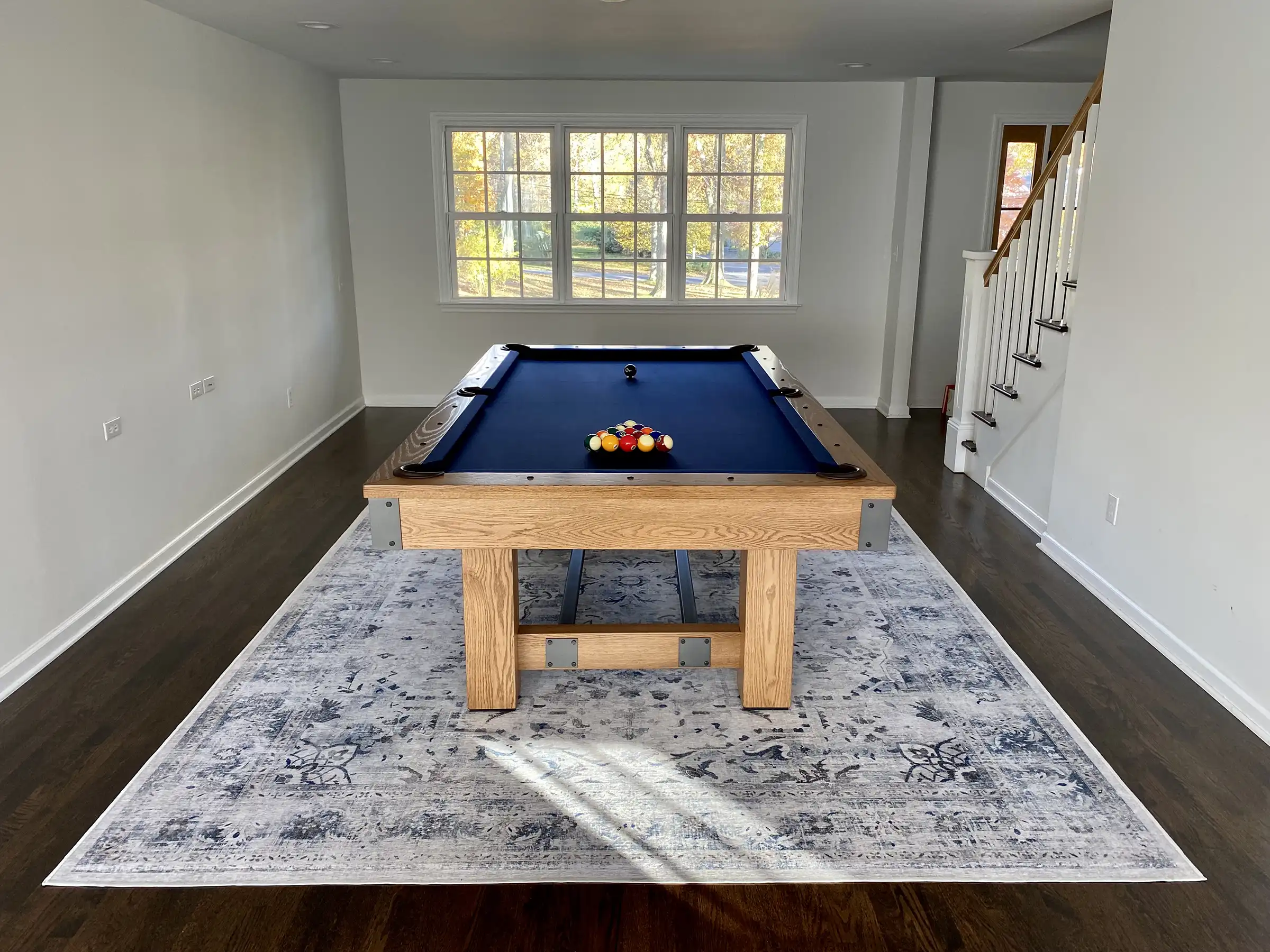 a blue pool table in a room on a shabby chic rug