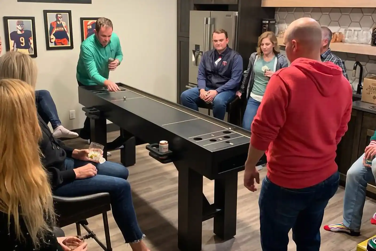 Group of people playing on a black skeech table in the kitchen