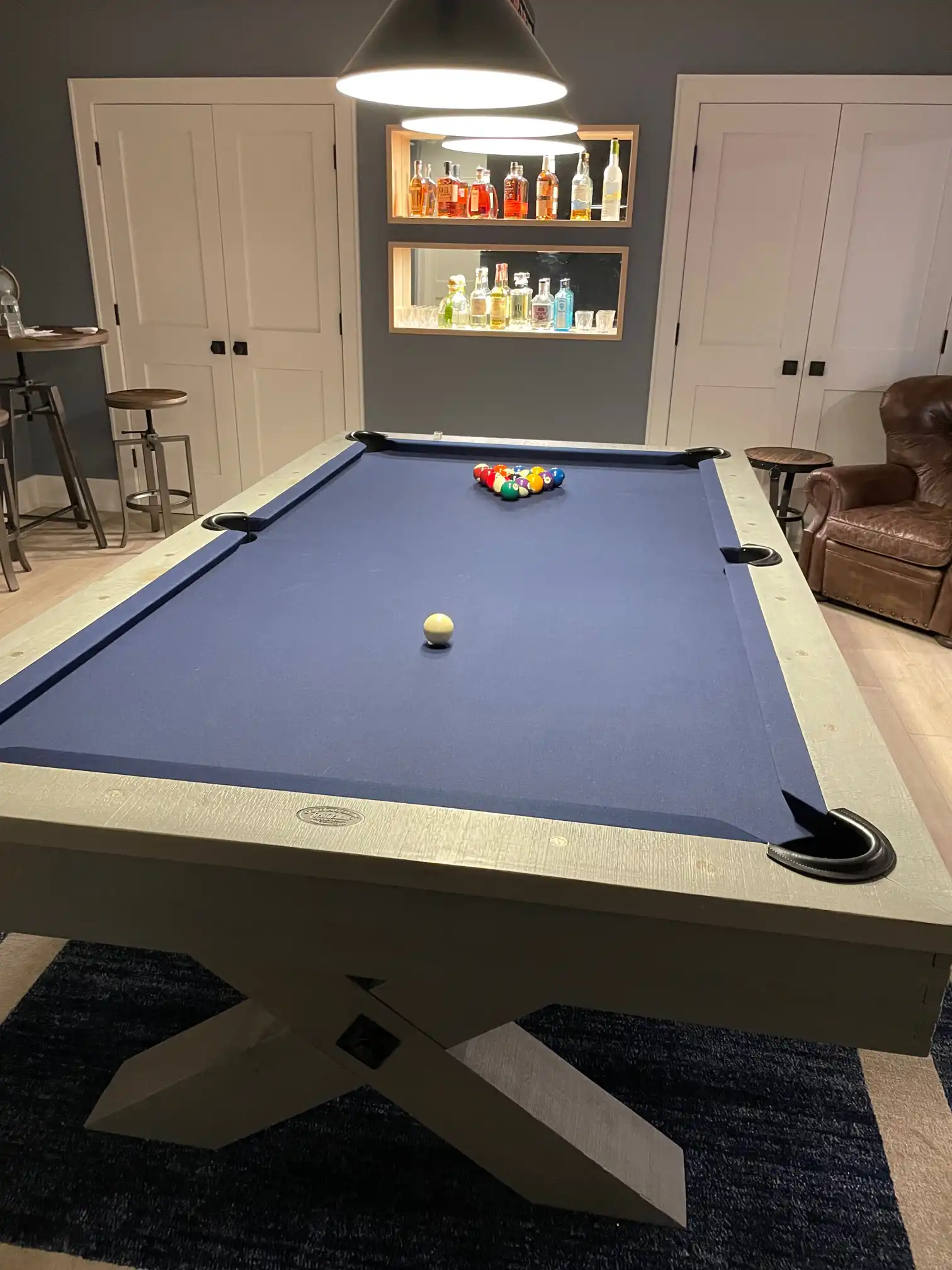 blue Olhausen pool table with a bar in the background