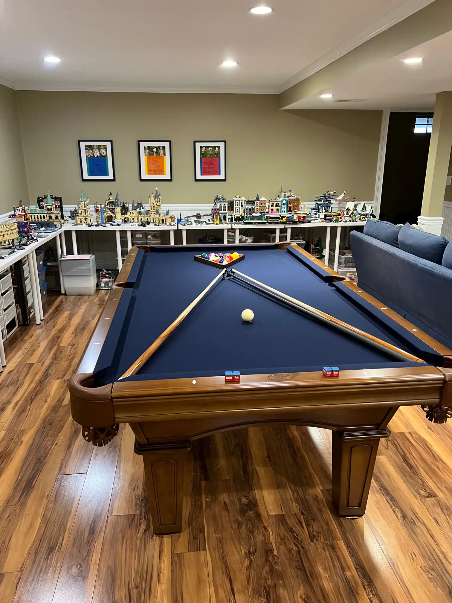 blue Olhausen pool table with a bunch of lego sets in the background