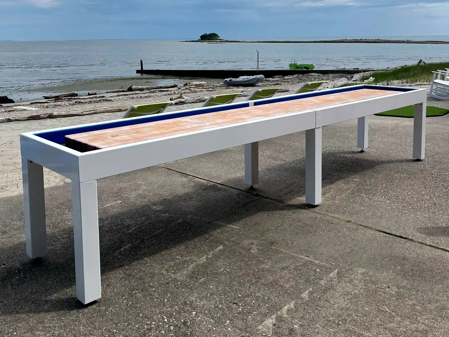 an outdoor shuffleboard table next to the ocean