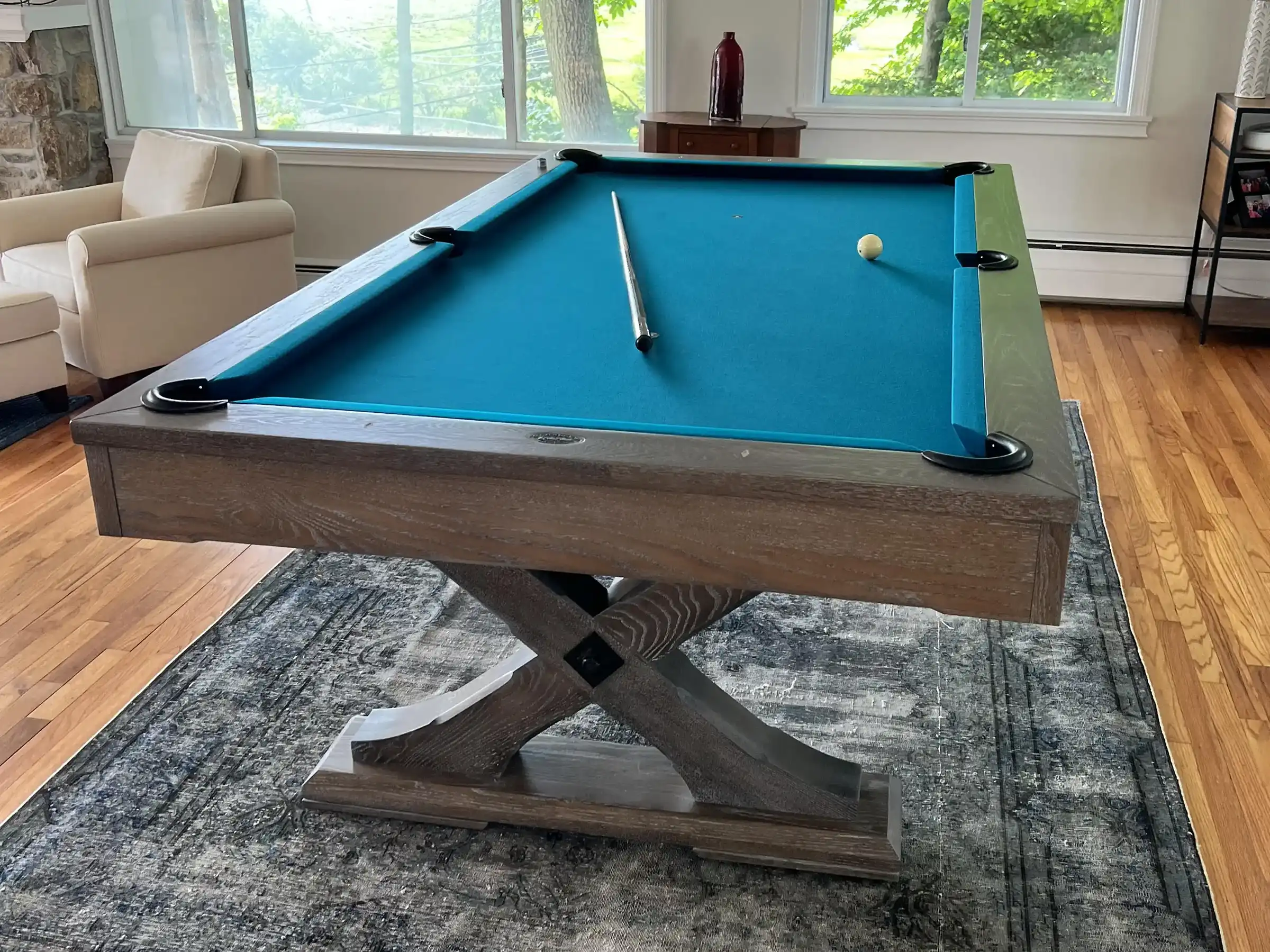 Olhausen pool table with blue felt on a grey carpet