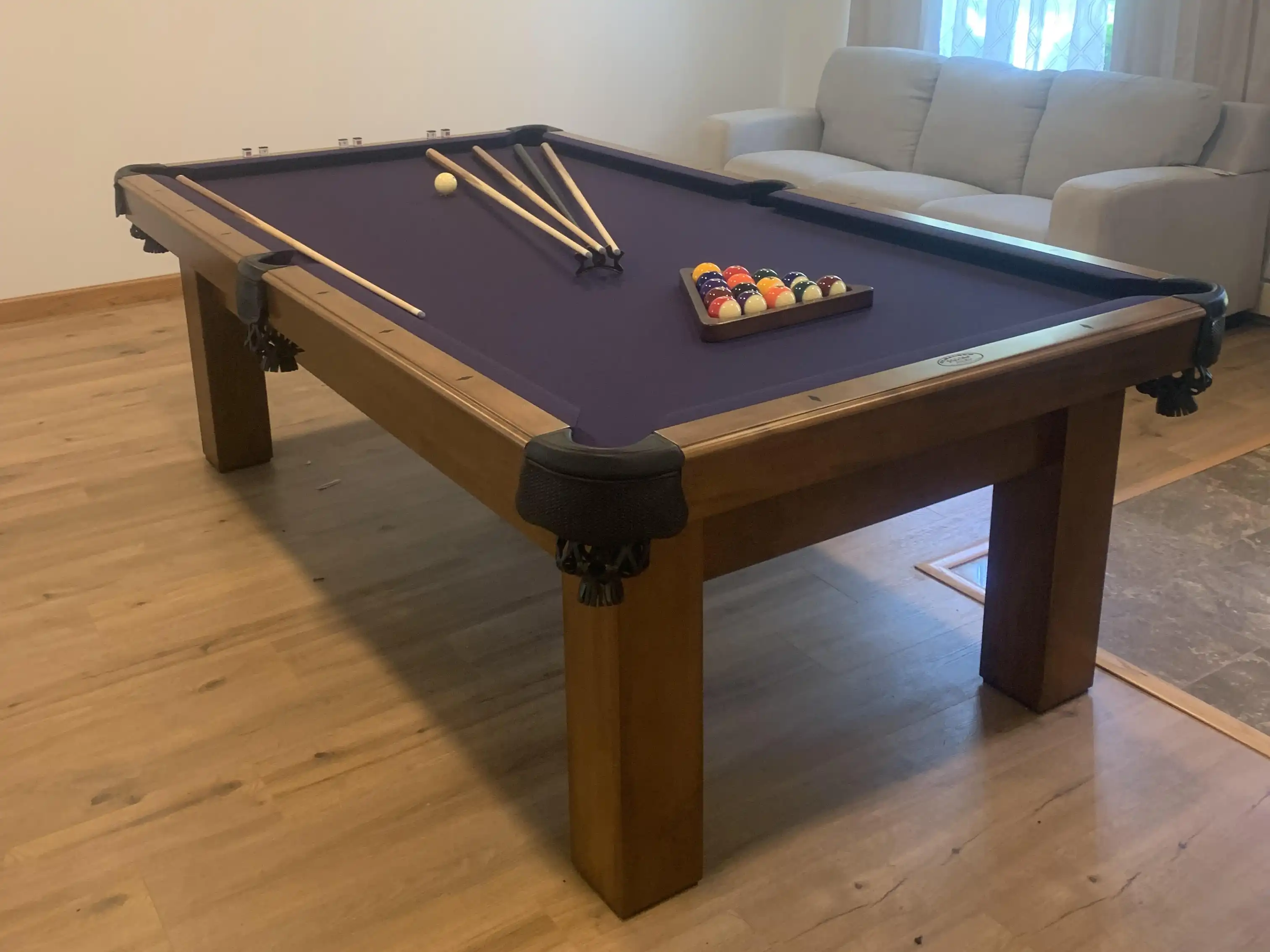 Dark blue Olhausen pool table in a room with a oak hardwood floor